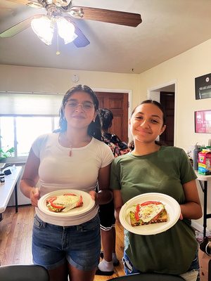 Two youth showing plates of food they prepared